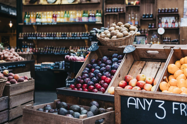 Variedad de frutas y verduras frescas en cajas de madera, a la venta en un puesto de mercado
. - Foto, imagen