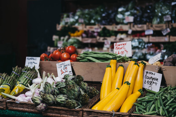 Scala aan verse groenten in houten kratten te koop op een marktkraam. - Foto, afbeelding