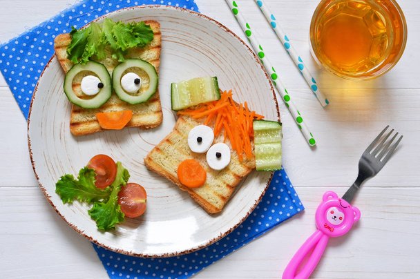 Breakfast for a child - children's funny toasts with a grilled and carrot. - Photo, image