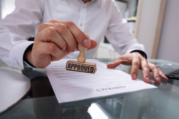 Businessman's Hand Stamping Approved On Contract Paper With Stamper - 写真・画像
