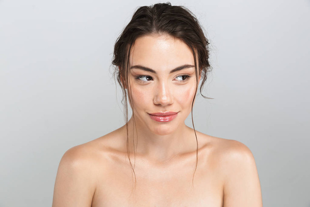 Beauty portrait of a pretty young topless woman with make-up looking away isolated over gray background - Φωτογραφία, εικόνα