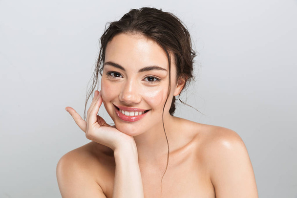 Beauty portrait of a happy young topless woman with make up looking at camera isolated over gray background - Foto, immagini