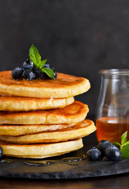Homemade oat pancakes with honey and blueberries for breakfast on a stone plate. Good morning! - Photo, Image