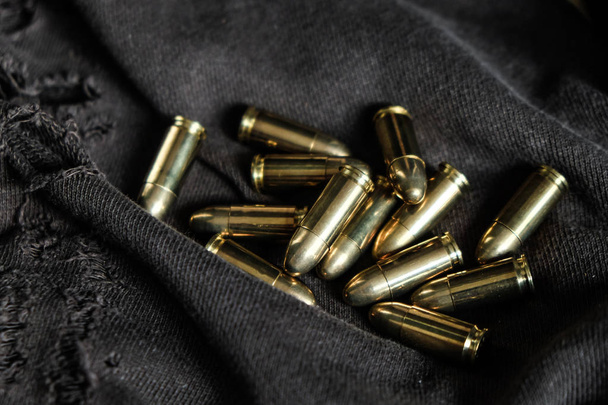 Full metal jacket 9mm Rüger golyó a ruha textúrája kar objektum - Fotó, kép