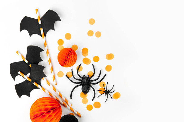 Halloween holiday decorations and straws with paper bats on white background - 写真・画像