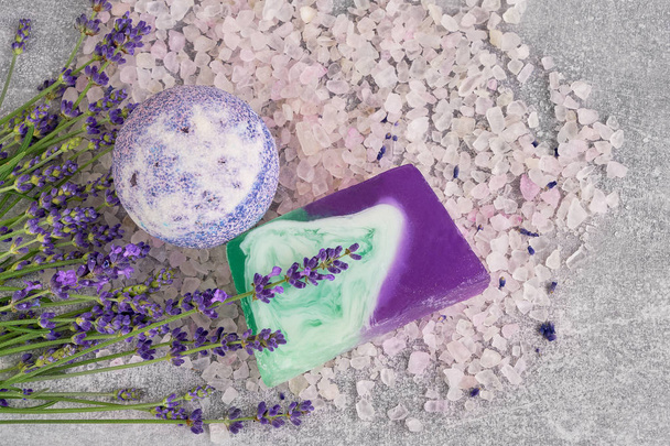 ätherisches Lavendelsalz, Seife und Badebombe mit Blumen von oben. Wellness-Lavendelprodukte. Ansicht von oben, Kopierraum. flache Lage - Foto, Bild