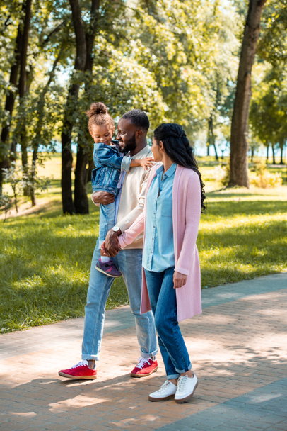 afroamericanos padres e hija caminando juntos en parque
 - Foto, Imagen