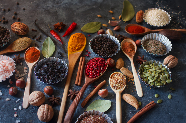 Various Indian spices in wooden spoons and metal bowls - Foto, imagen
