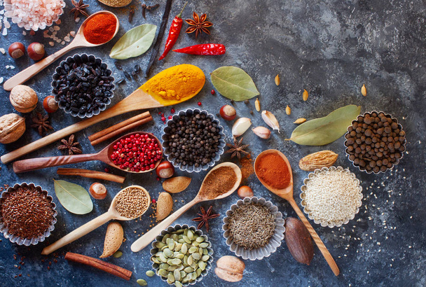 Various Indian spices in wooden spoons and metal bowls - Foto, imagen