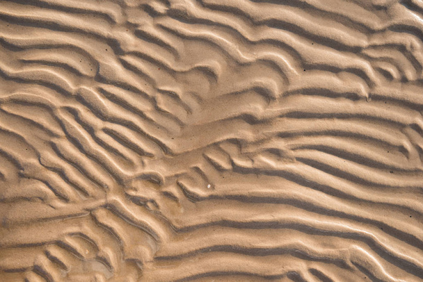 Sandhintergrund Textur unter Wasser. Transparentes Wasser plätschert, Sandwellen und Sonnenlicht blenden. Hintergrund des Meeresbodens - Foto, Bild