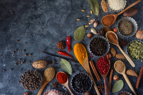 Various Indian spices in wooden spoons and metal bowls - Foto, Imagen