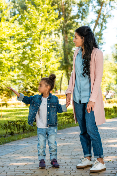 african american daughter pointing on something to mother in park - Photo, Image