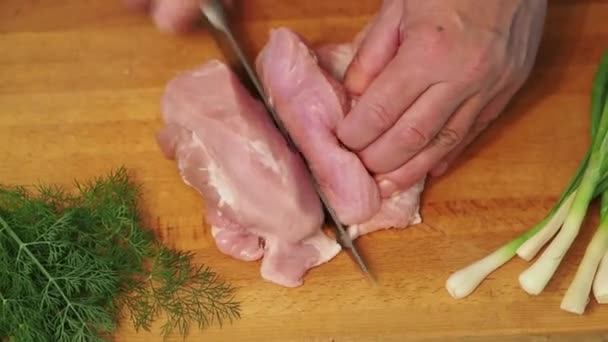 The man knifes a big piece of meat. Top view. - Filmati, video