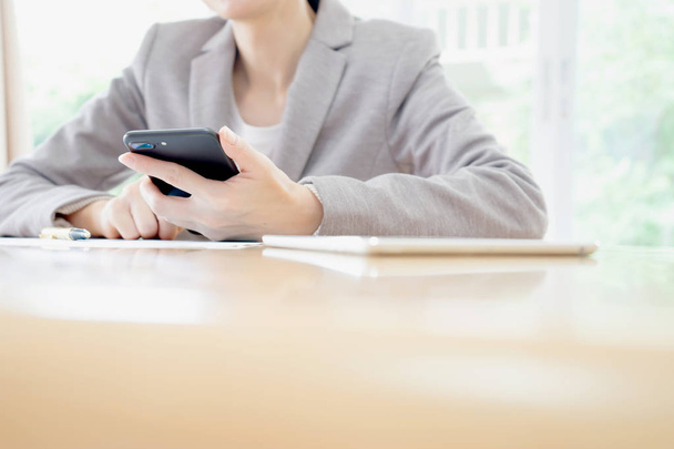 Businesswoman holding smartphone at the office  - Photo, Image