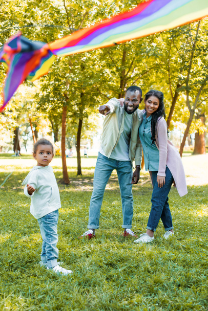 公園で娘に凧の飛行で指しているアフリカ系アメリカ人の父 - 写真・画像