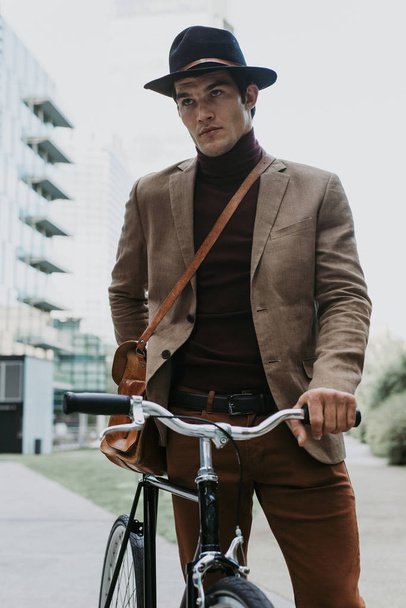 Handsome young business man with his modern bicycle. - Valokuva, kuva