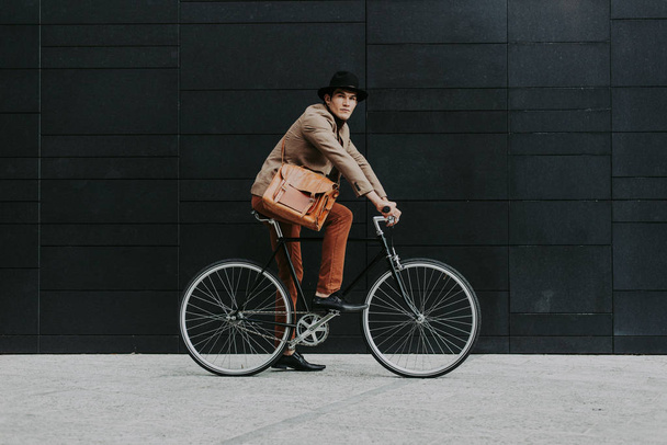 Handsome young business man with his modern bicycle. - Foto, afbeelding