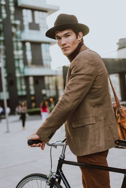 Handsome young business man with his modern bicycle. - Photo, image