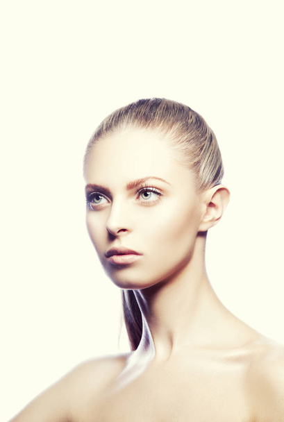 Portret van jonge modieuze aantrekkelijke blonde vrouw met kapsel en natuurlijke make-up op beige achtergrond  - Foto, afbeelding