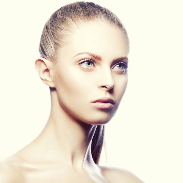 Porträt einer jungen modischen attraktiven blonden Frau mit Frisur und natürlichem Make-up auf beigem Hintergrund  - Foto, Bild