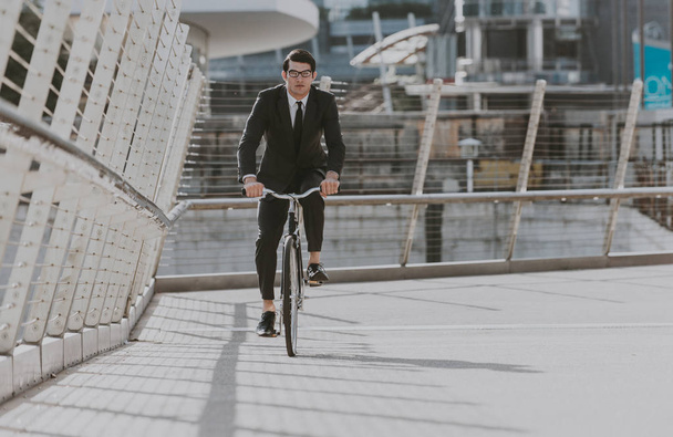 Handsome young business man with his modern bicycle. - Foto, Imagen