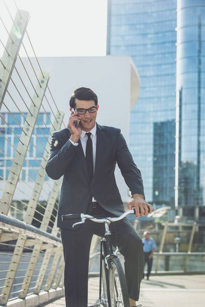 Handsome young business man with his modern bicycle. - Foto, imagen