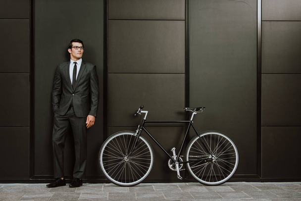 Handsome young business man with his modern bicycle. - Photo, image