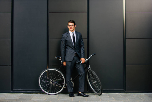 Handsome young business man with his modern bicycle. - Foto, Imagen