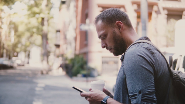 Vertrouwen succesvolle zakenman van de Kaukasische staande op de hoek van de straat van de stad met koffie met behulp van mobiel kantoor smartphone app - Video
