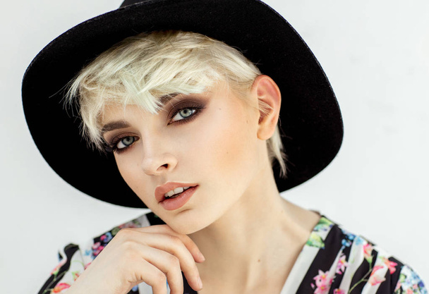 Beauty portrait of fashion blond model in a hat touching her chi - Foto, afbeelding