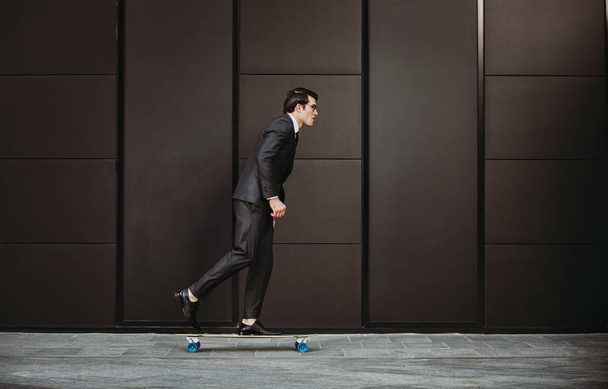 Handsome young business man with his modern longboard - Foto, immagini