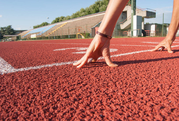 Дві руки жінки готові бігати по легкій атлетичній трасі
 - Фото, зображення