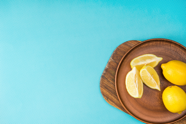 Turkuaz ile kopya alanı üzerinde ahşap tahta üzerinde limon seramik plaka üstten görünüm - Fotoğraf, Görsel