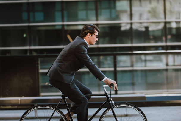 Handsome young business man with his modern bicycle. - 写真・画像