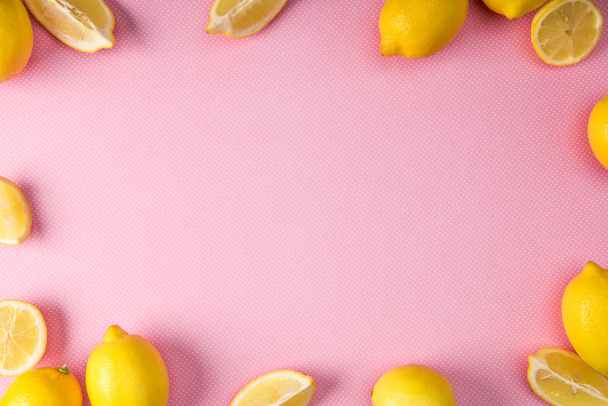 top view of frame made from fresh yellow lemons on pink background - Foto, Bild