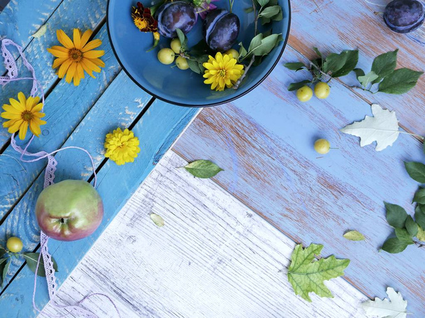 Composição sazonal decorativa, em um fundo de madeira leve frutas, legumes, folhas de outono e flores, vista superior
 - Foto, Imagem