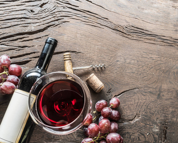 Wine glass, wine bottle and grapes on wooden background. Wine tasting. - 写真・画像