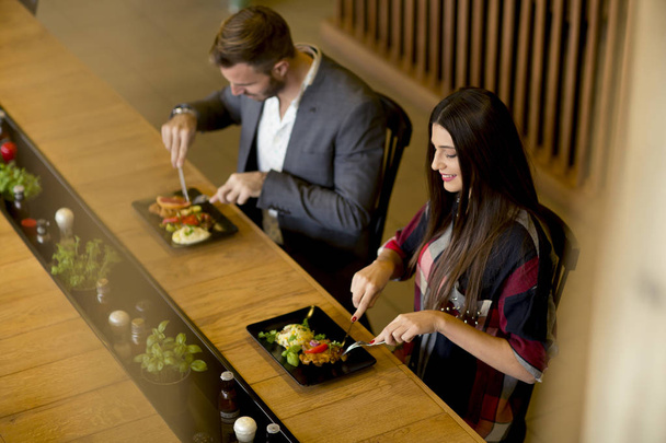 Молодая любящая пара обедает в современном ресторане
 - Фото, изображение