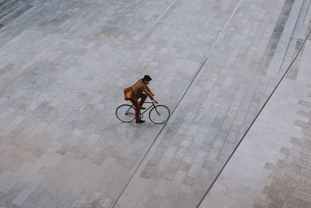 Handsome young business man with his modern bicycle. - Фото, изображение