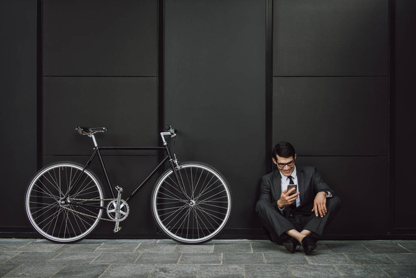 Handsome young business man with his modern bicycle. - Foto, imagen
