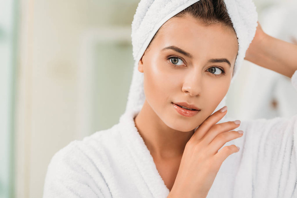 portrait of beautiful young woman in bathrobe and towel on head - Foto, Imagen