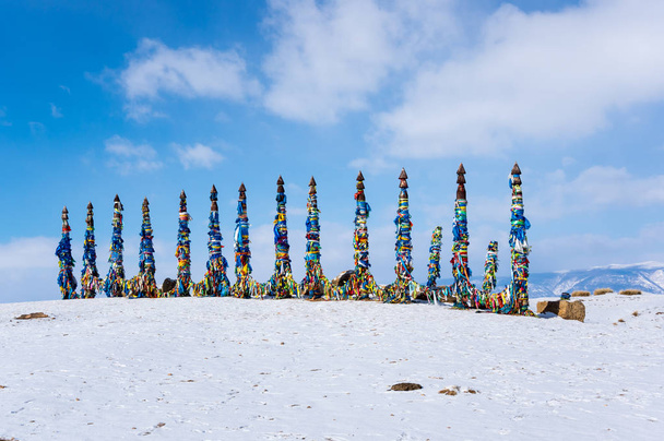 Wooden ritual pillars with colorful ribbons on cape Burkhan, Lake Baikal, Olkhon Island, Siberia, Russia - Фото, изображение