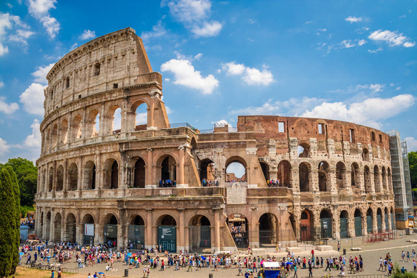 Colosseum with clear blue sky and clouds, Rome, Italy, Europe. Rome ancient arena of gladiator fights. Rome Colosseum is the best known landmark of Rome and Italy - Photo, Image