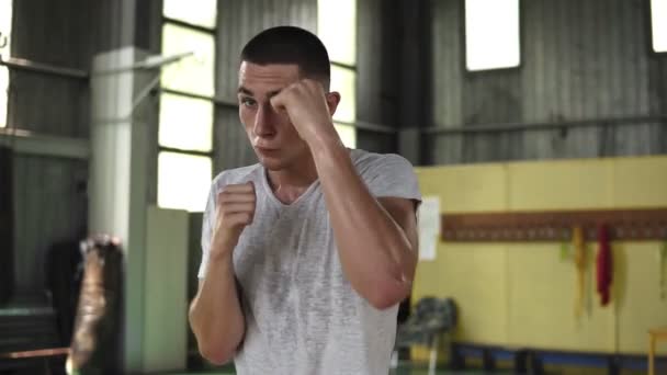 Retrato de homem ativo forte no boxe e soco oponente invisível durante o treinamento em ginásio, câmera lenta. Fechar
 - Filmagem, Vídeo