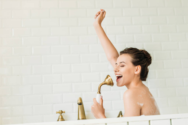 hermosa chica feliz cantando y divertirse en la bañera
 - Foto, Imagen