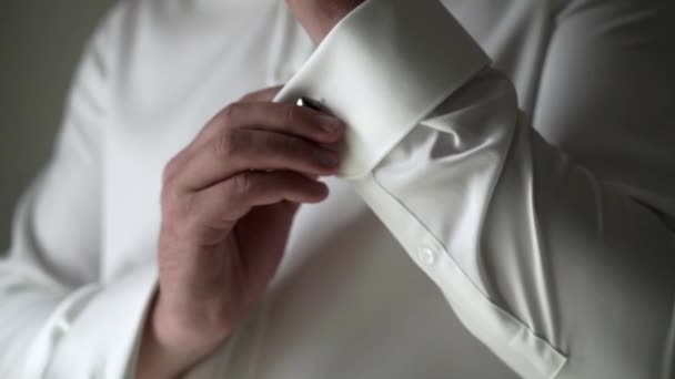 Young man in white shirt put on cuff links - Záběry, video