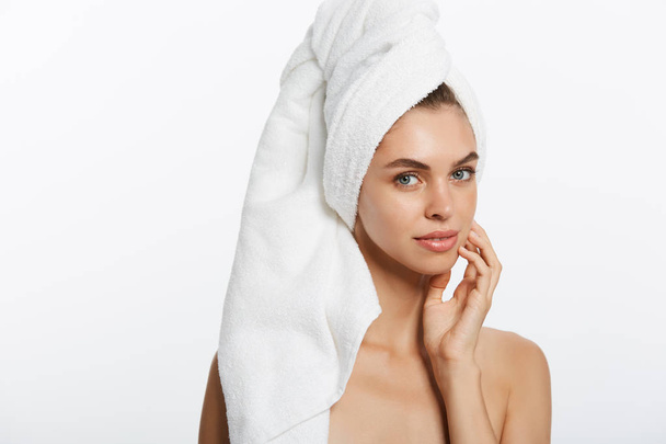 Spa and beauty concept - happy young girl with clean skin and with a white towel on her head washes face - Photo, Image