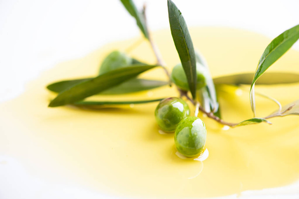Three olives and olive oils with leaves  on white background  - Foto, Imagen