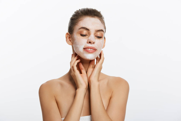 Primer plano de una mujer con máscara facial cosmética aplicada sobre su cara mirando hacia otro lado
. - Foto, Imagen
