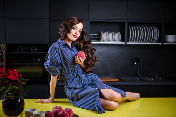 Beautiful young woman in a kitchen room, casual clothes, lifestyle portrait - 写真・画像